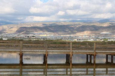 Göl ve dağ gölgelerini bulutlar ile arka plan üzerinde ahşap köprü