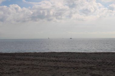 Yelkenli teknelerde sakin deniz ve bulutlu gökyüzü ufukta