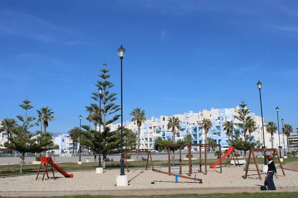 Çocuk s oyun alanı ot ve çam ağaçları ile kum üzerinde