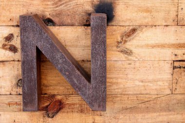 Paslı demir ahşap arka plan üzerinde yapılan N harfi