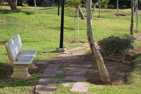 White stone bench in recreational park and stone path