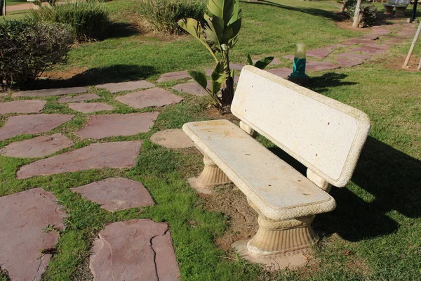 White stone bench in recreational park and stone path