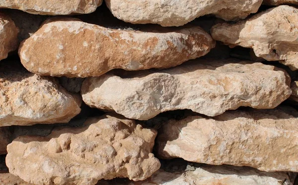 Wall of brown stones stacked and glued with cement