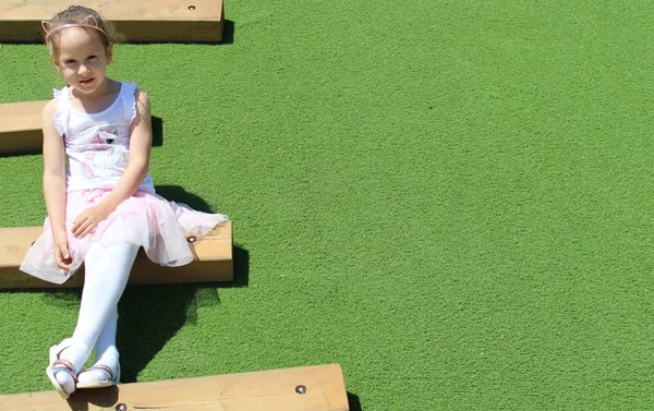 Küçük kız ahşap bir adım üzerinde oturan