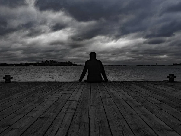 Ahşap iskele Helsinki'de bir adam oturup.