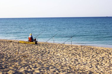 turist Balık tutma. Bir balıkçı sahil üzerinde bir olta ile Balık tutma. Denizde balık tutma