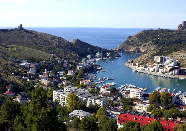 Denizin kenarında deniz liman kenti. Yatlar Mavi denizin iskelede. Beyaz tekneler ve yatlar liman kenti yeşil dağların fon karşı. Yün Crimea'da. 