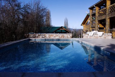 Temiz, temiz, mavi su havuzu yazlık topraklarının üzerinde. Mavi su ile açık havuz kenarında açık hava etkinlikleri. 