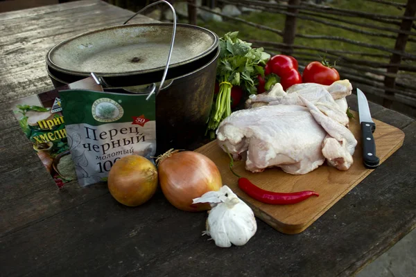 Piknik niteliğine ateşe yemek. Et yemekleri ateş üzerinde pişirme için malzemelerin listesini: tavuk, domates, biber, baharat, soğan. 