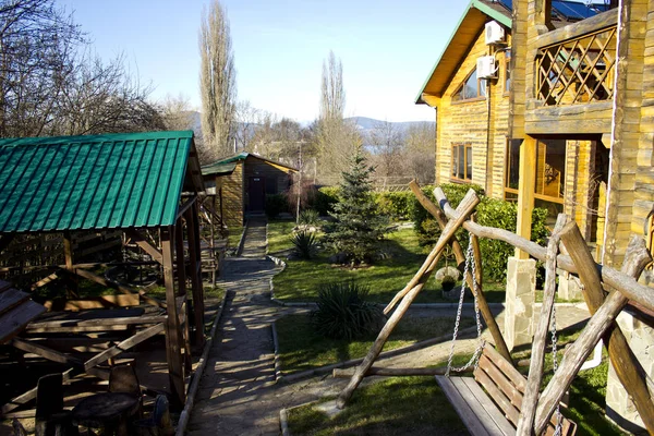 Camping in a wooden house among the green lush vegetation. BBQ and gazebos for outdoor recreation in a wooden cottage.