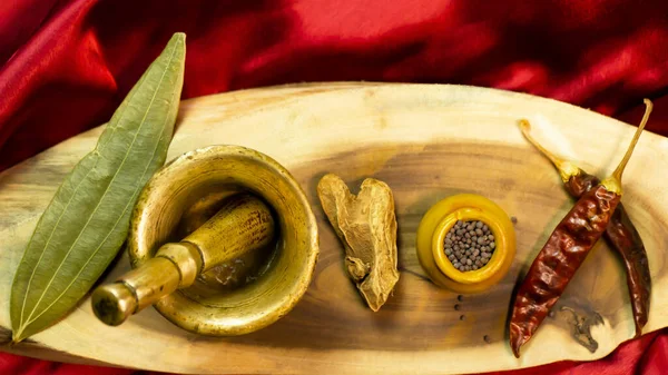 Hindistan çiğ baharatlarının ahşap bir zemindeki renkli küçük kil kaplar üzerinde düzenlenmesi. 