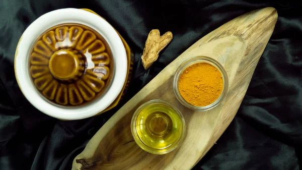 Hindistan çiğ baharatlarının ahşap bir zemindeki renkli küçük kil kaplar üzerinde düzenlenmesi. 