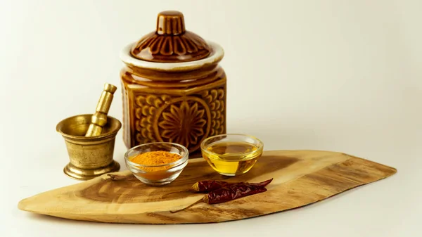Hindistan çiğ baharatlarının ahşap bir zemindeki renkli küçük kil kaplar üzerinde düzenlenmesi. 