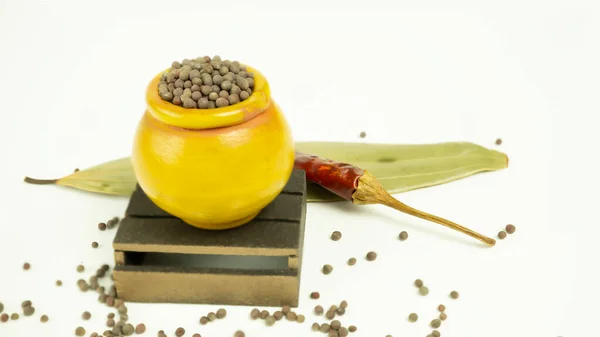 Hindistan çiğ baharatlarının ahşap bir zemindeki renkli küçük kil kaplar üzerinde düzenlenmesi. 