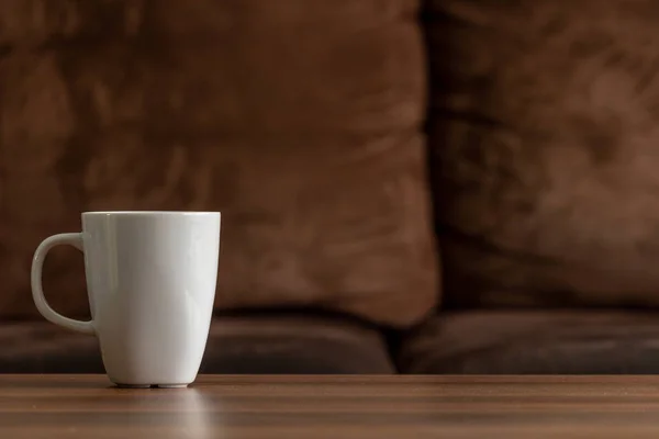 Caneca Branca Uma Mesa Madeira Com Fundo Sofá Marrom Copiar — Fotografia de Stock