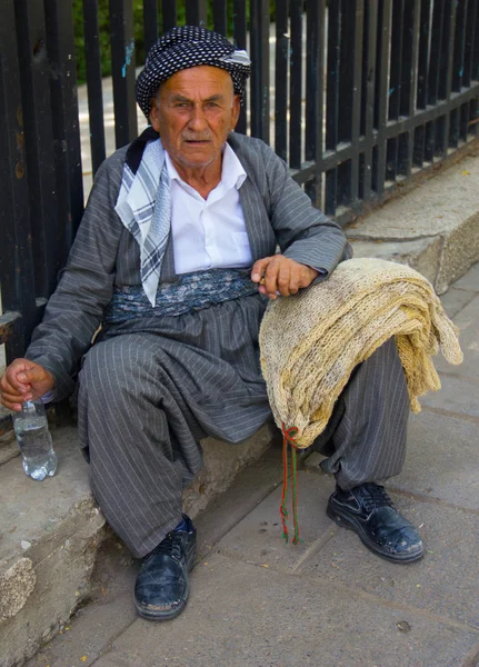 Yaz sıcağında oturarak yorgun yaşlı bir Kürt adam
