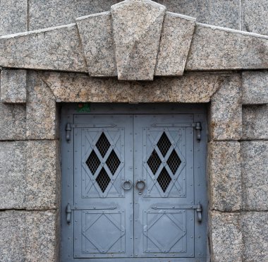 St. Petersburg 'da granit bir duvarda elmas şekilli küçük pencereli demir gri kapılar.