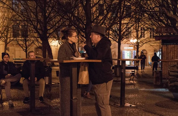 Prag, Çek Cumhuriyeti - 10 Mart 2020, Prag 'ın tarihi sokaklarında bir erkek ve bir kadın gece iletişim kuruyor.