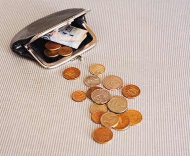 Siyah cüzdanın etrafındaki farklı ülkelerden gelen pek çok madeni para masaya saçılmıştır: dolar, pound, ruble, kuruş, sent, yuan. Tasarruf, finans kaybı, kazanç.