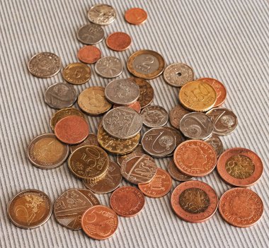 Siyah cüzdanın etrafındaki farklı ülkelerden gelen pek çok madeni para masaya saçılmıştır: dolar, pound, ruble, kuruş, sent, yuan. Tasarruf, finans kaybı, kazanç.