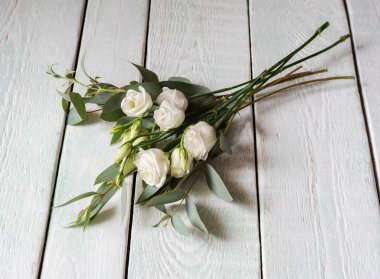 Beyaz güller ve okaliptüslü narin bir buket.