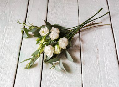 Beyaz güller ve okaliptüslü narin bir buket.