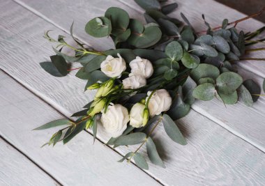 Beyaz güller ve okaliptüslü narin bir buket.