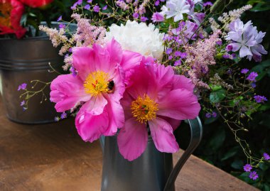 Çiçek açan şakayıklar ve kır çiçekleri.