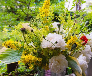 Çiçek açan şakayıklar ve kır çiçekleri.