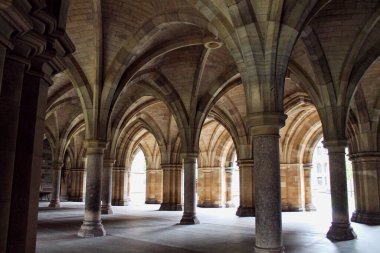 Glasgow, İskoçya - 1 Ağustos 2020, Glasgow Üniversitesi 'nin taş gotik cephesi, avluya taş kemerler