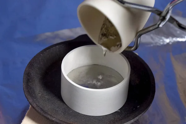 Наливання розплавленого свинцю в керамічний посуд. Термостійка кераміка . — стокове фото