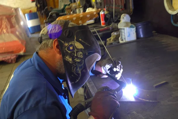 Kaynakçı metal parçaları bir Workbench üzerinde kaynak.