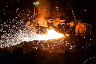 Çelik fabrikasında erimiş demir akıntısı.