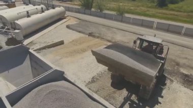 Bir buldozer kova kullanarak tankta Pellet ve moloz döküntüsü. Asfalt tesisi
