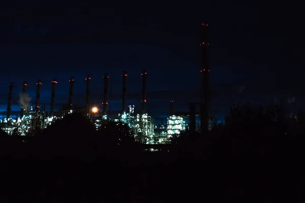 Refinaria de petróleo à noite iluminada. Construção de uma fábrica industrial de petróleo — Fotografia de Stock