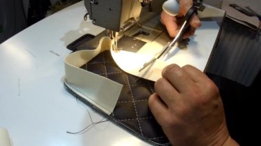 Araba için bir halı yapma, el yapımı, deri halı ve eski bir dikiş makinesi görünümü.