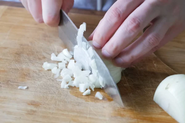 Cipolle di taglio su un tagliere in cucina . — Foto Stock