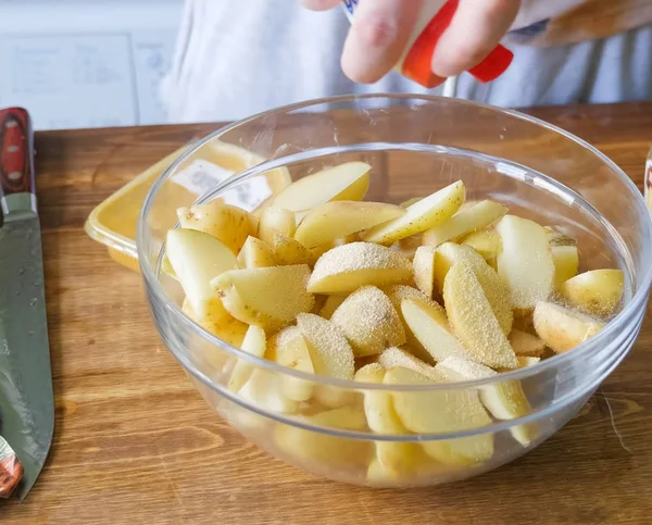 Rauwe aardappelen snijden en schillen op tafel in een plaat — Stockfoto