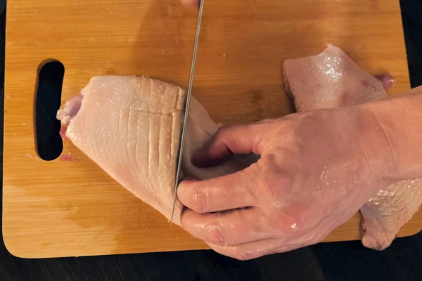 Rebanar pechugas de pollo en la tabla de cortar, cocinar carne de aves . — Foto de Stock