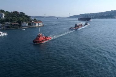 Nehir boyunca büyük boyutlu kargo taşımacılığı, bir mavna üzerinde bir damıtma sütun fabrikaya yüzer.