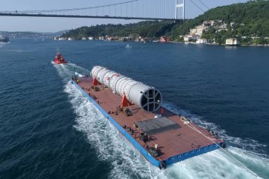 Nehir boyunca büyük boyutlu kargo taşımacılığı, bir mavna üzerinde bir damıtma sütun fabrikaya yüzer.