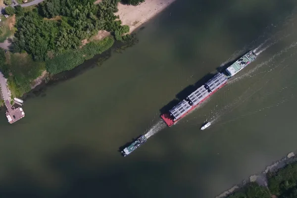 Ponadwymiarowy transport ładunków wzdłuż rzeki, Kolumna destylacyjna na barki pływaków do fabryki. — Zdjęcie stockowe