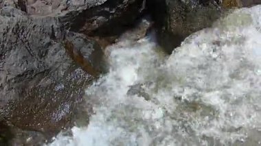 Sahilde sıralanmış büyük taşlar. Çamurlu dalgalar.
