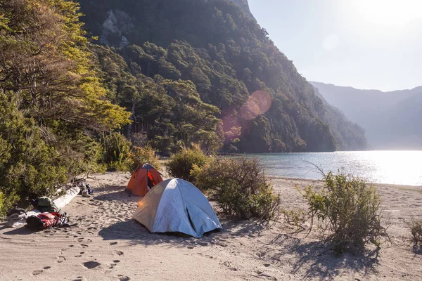 Two tents in a campsite near a lagoon in the mountain / Camping gear isolated / Camping next to a lake in the morning or the afternoon