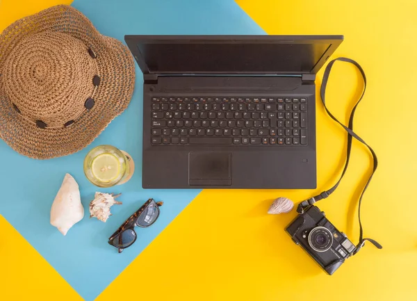 Flat lay work and travel, beach and tropical theme, with copy space for text. Top view of workplace and vacation concept with blank space with summer or spring accesories on yellow and blue background