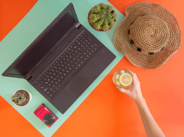 Flat lay work and travel, fresh and cactus theme, with young women hands and copy space for text.Top view of millennial workplace and vacation concept with blank space with summer or spring accesories
