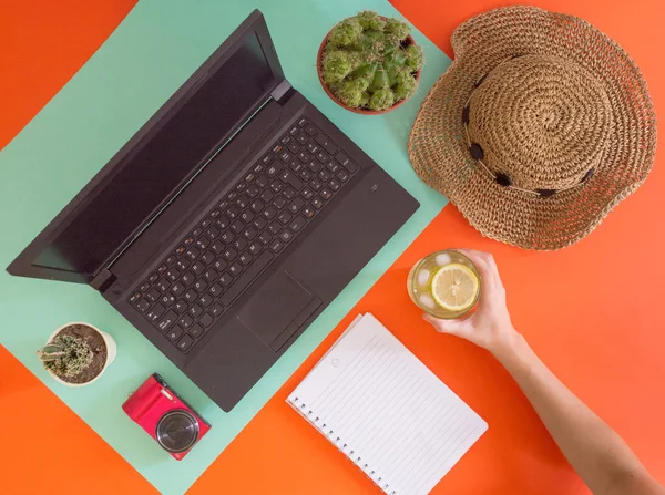 Flat lay work and travel, fresh and cactus theme, with young women hands and copy space for text.Top view of millennial workplace and vacation concept with blank space with summer or spring accesories