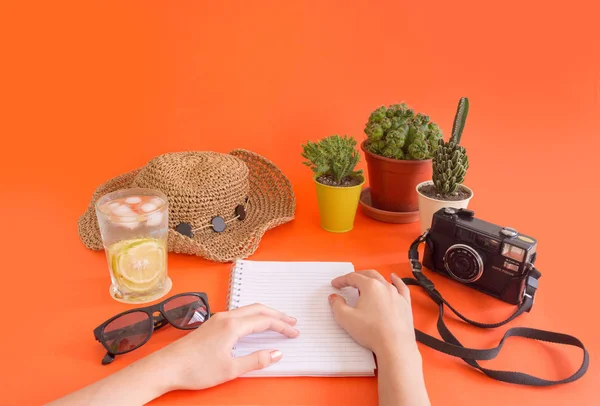 Work and travel, fresh and cactus theme, with copy space for text. View of workplace. Vacation and summer sale concept. Tourism accesories for travel preparation, with blank space on orange background