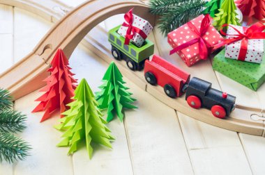 Bir oyuncak ahşap tren çocuk için bir hediye ile bir kutu taşır. Noel sihirli şehir. Kağıt ağaç ve yıldız, dekorasyon tatil için. Yılbaşı oyuncak.