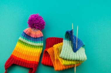 Bir gökkuşağı atkı ve şapka örgü. İğneler örgü yün topları sepetle. Mavi arka plan. En sevdiğim iş bir hobi olduğunu.